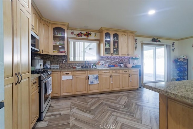 kitchen with light parquet flooring, stainless steel appliances, light brown cabinetry, sink, and light stone counters