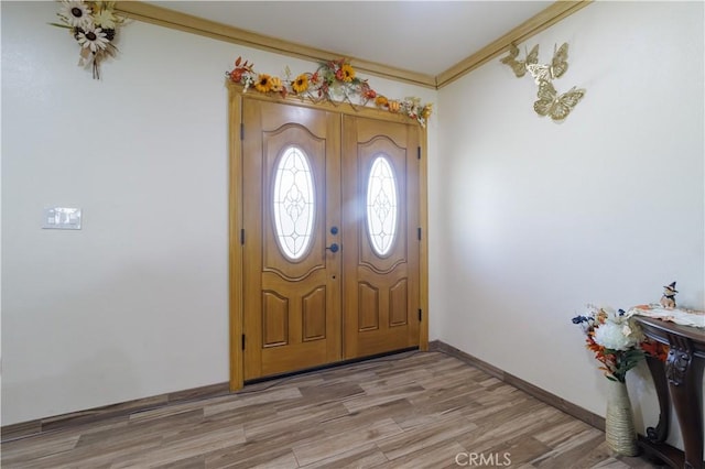 entryway featuring ornamental molding and light hardwood / wood-style floors