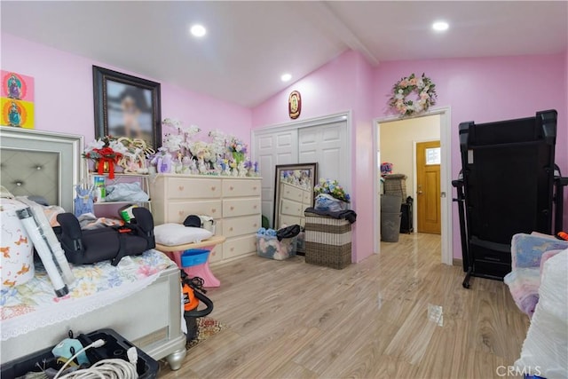 bedroom with a closet, lofted ceiling with beams, and light wood-type flooring