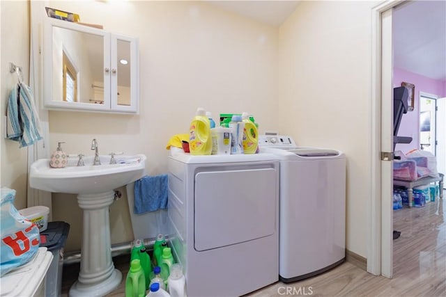 laundry room with sink, light hardwood / wood-style flooring, and washing machine and dryer