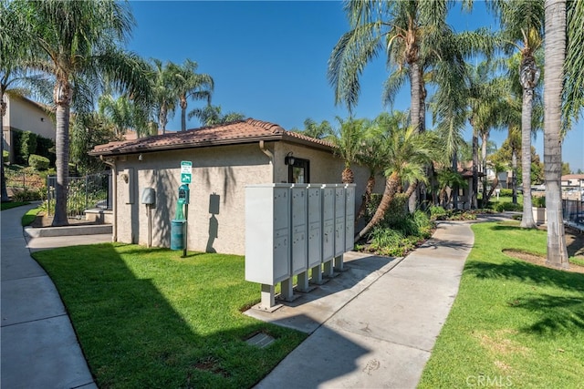 view of side of home with a yard and a mail area