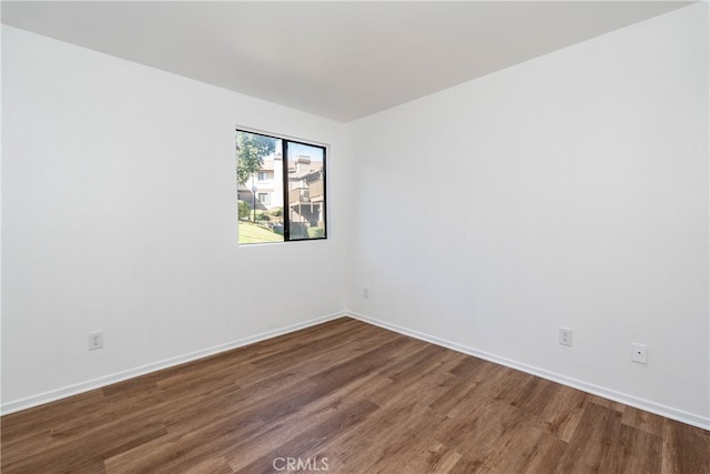 unfurnished room with dark wood-type flooring