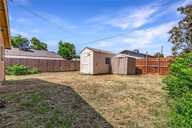 view of yard featuring central AC unit and a storage unit