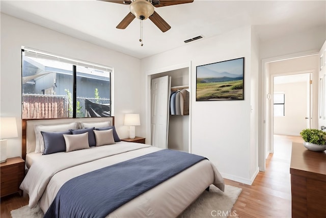 bedroom with a closet, light hardwood / wood-style flooring, and ceiling fan