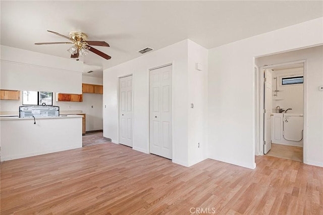 kitchen featuring kitchen peninsula, ceiling fan, and light hardwood / wood-style flooring