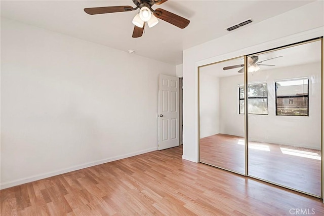 unfurnished bedroom with light hardwood / wood-style flooring, a closet, and ceiling fan