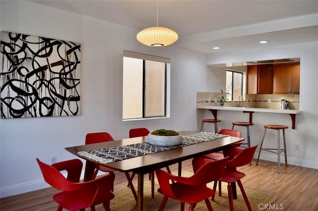 dining space with light wood-style flooring, recessed lighting, and baseboards