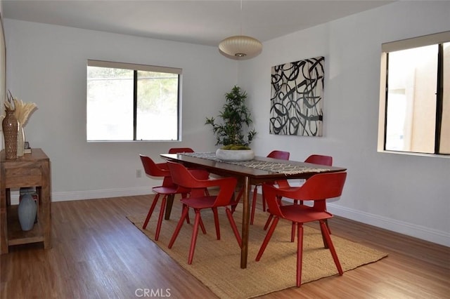 dining space with baseboards and wood finished floors