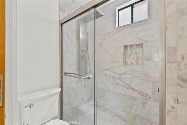 full bath with a marble finish shower and toilet