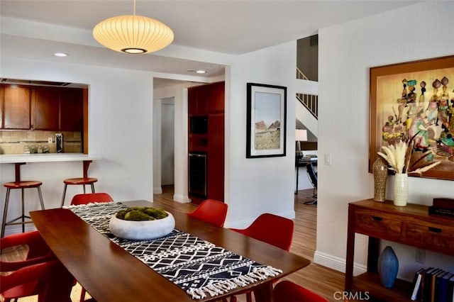 dining area with wood finished floors, baseboards, and recessed lighting