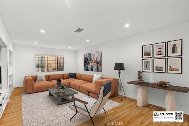 living room featuring light wood-style floors, visible vents, and recessed lighting