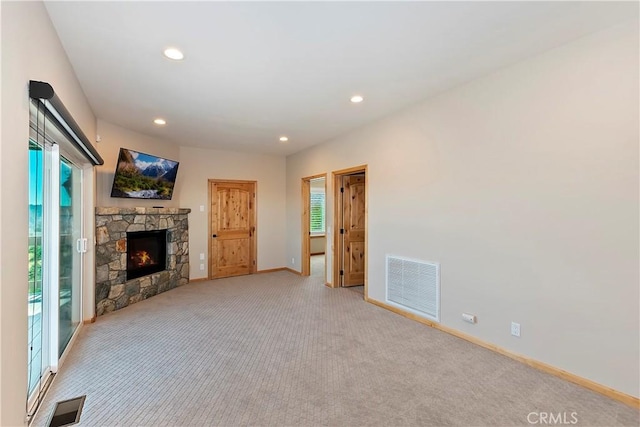 unfurnished living room with a fireplace and light colored carpet