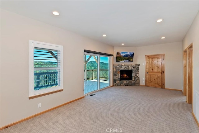 unfurnished living room featuring light colored carpet and a healthy amount of sunlight