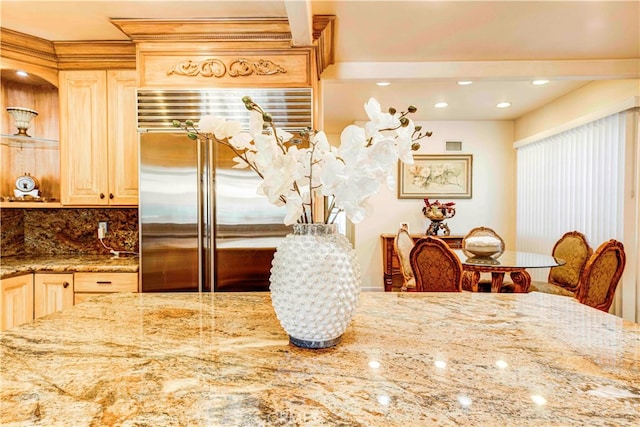 interior space with stainless steel built in fridge, light brown cabinets, and stone counters