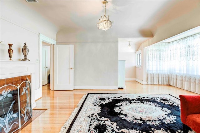 interior space featuring light hardwood / wood-style floors, a fireplace, and a chandelier