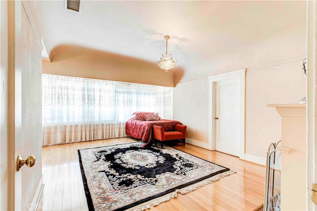 living area with an inviting chandelier and hardwood / wood-style flooring