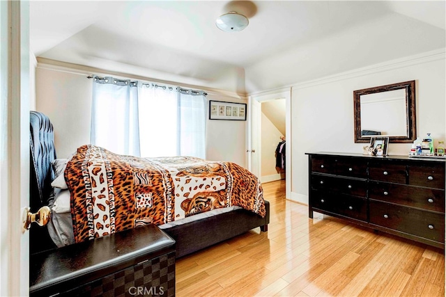 bedroom featuring a closet, light hardwood / wood-style floors, and a walk in closet