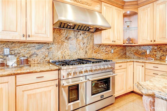 kitchen featuring light stone counters, exhaust hood, range with two ovens, and light brown cabinets