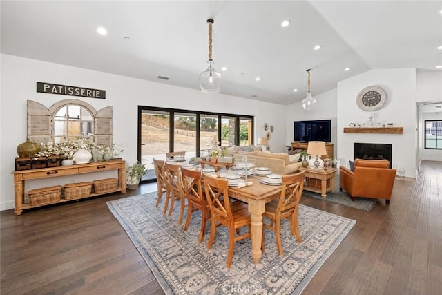 dining area with vaulted ceiling and dark wood-type flooring