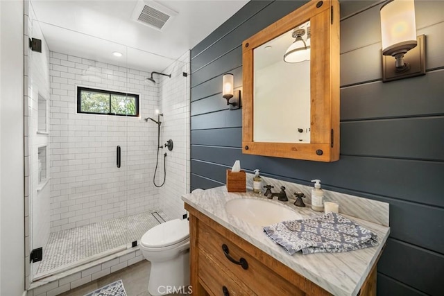 bathroom with vanity, a shower with shower door, and toilet