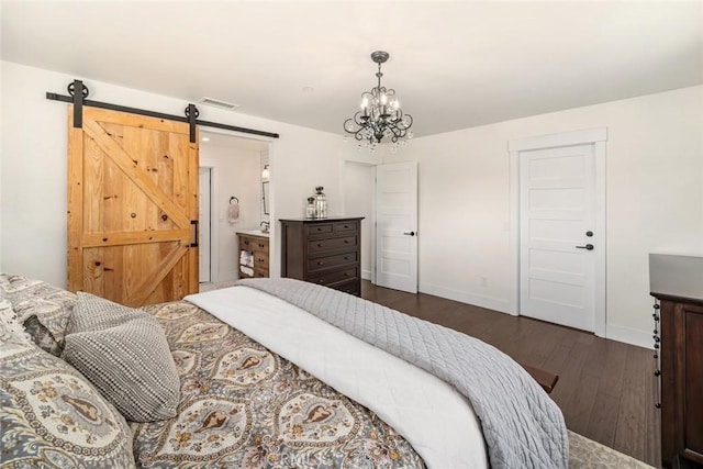 bedroom with a barn door, dark hardwood / wood-style flooring, and an inviting chandelier