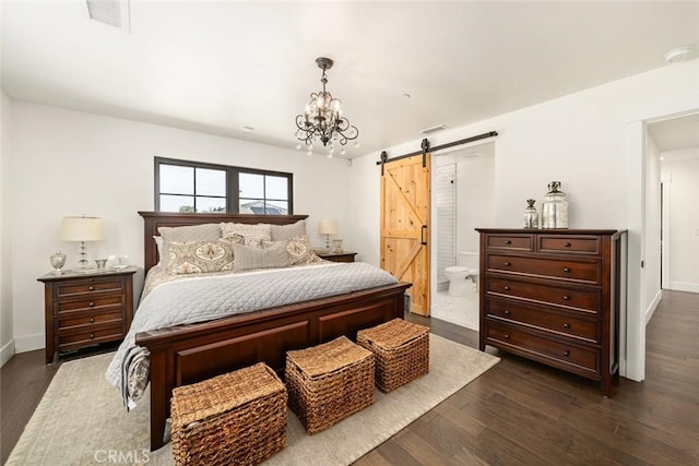 bedroom with a barn door, dark hardwood / wood-style flooring, connected bathroom, and a chandelier