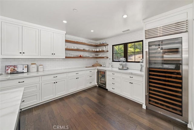 kitchen featuring tasteful backsplash, dark wood-type flooring, white cabinets, and beverage cooler