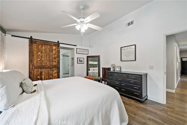 bedroom with ceiling fan, lofted ceiling, dark wood-type flooring, and a barn door