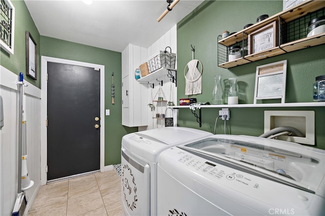 clothes washing area with light tile patterned floors and washer and clothes dryer