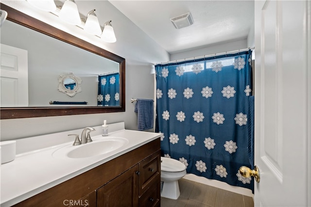 bathroom featuring curtained shower, vanity, and toilet