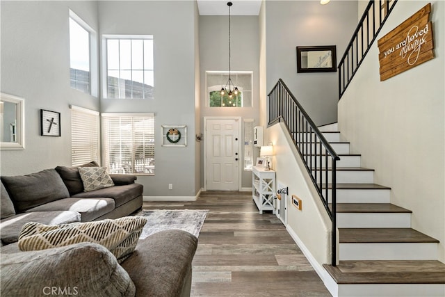 living room featuring a notable chandelier, a high ceiling, and wood-type flooring