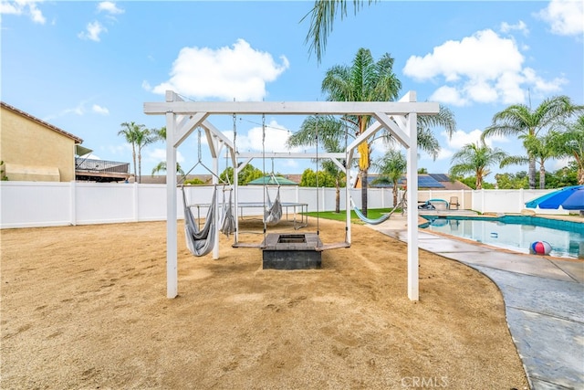 view of playground featuring a patio, an outdoor fire pit, and a fenced in pool