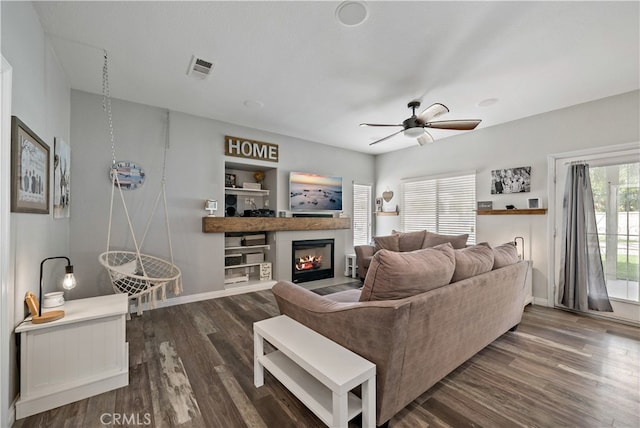 living room with a textured ceiling, ceiling fan, a healthy amount of sunlight, and dark hardwood / wood-style flooring