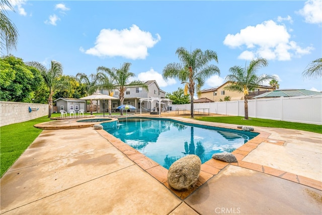 view of swimming pool featuring a lawn, a patio, and an in ground hot tub