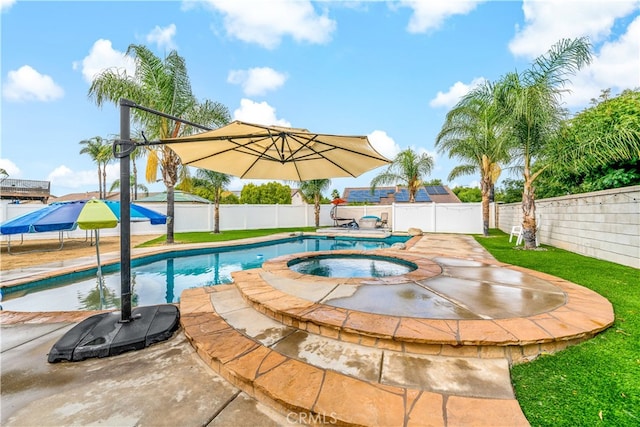 view of pool featuring a lawn, an in ground hot tub, and a patio area