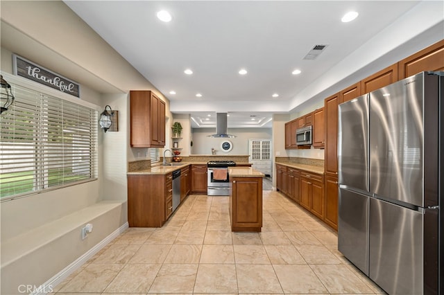 kitchen featuring sink, kitchen peninsula, island range hood, stainless steel appliances, and a center island