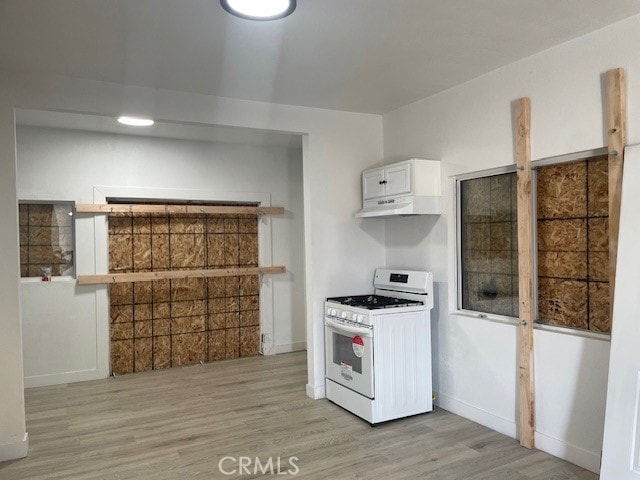 kitchen featuring light wood-type flooring, white cabinets, and white gas range oven