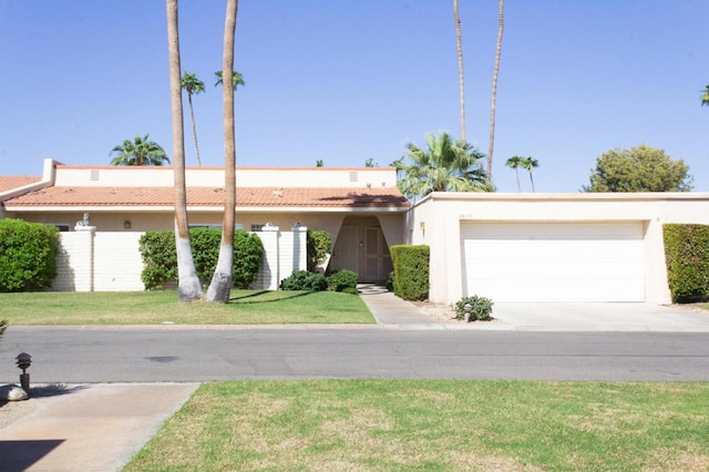 ranch-style house featuring a garage and a front lawn