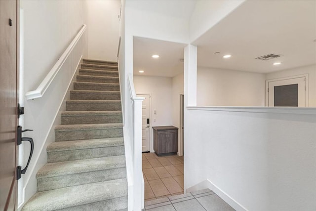 stairs featuring tile patterned flooring