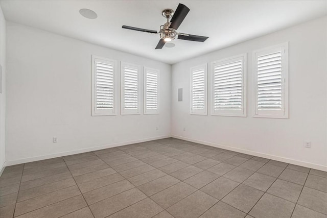 tiled spare room with ceiling fan