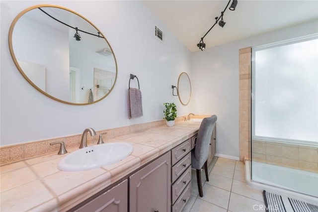 bathroom with a shower, tile patterned flooring, vanity, and rail lighting