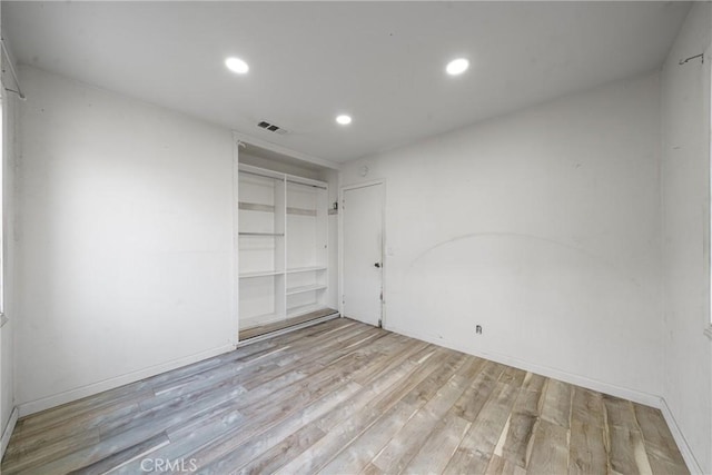 unfurnished bedroom featuring light hardwood / wood-style floors and a closet