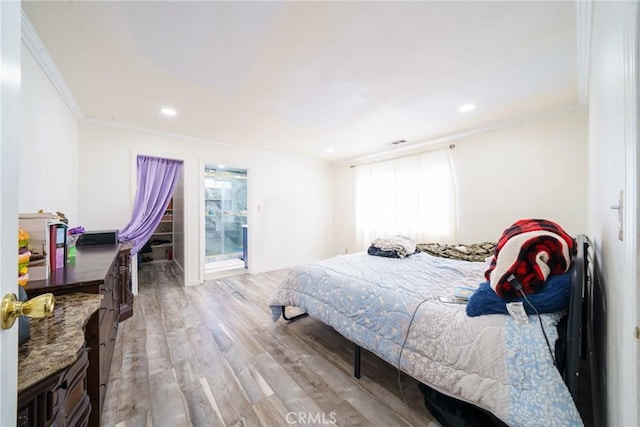 bedroom featuring crown molding and light hardwood / wood-style flooring