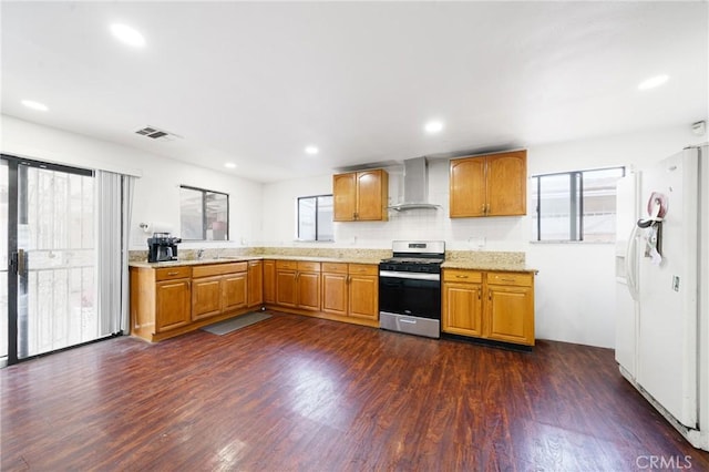 kitchen with stainless steel range, sink, wall chimney range hood, white refrigerator with ice dispenser, and dark hardwood / wood-style floors