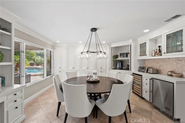 dining area featuring ornamental molding, beverage cooler, and light tile patterned flooring