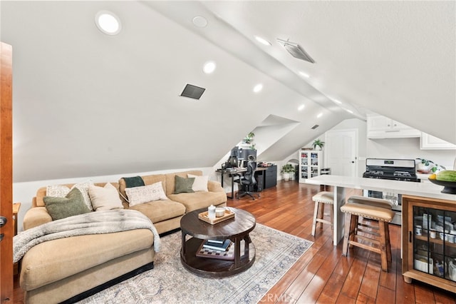 living room with beverage cooler, vaulted ceiling, and wood-type flooring