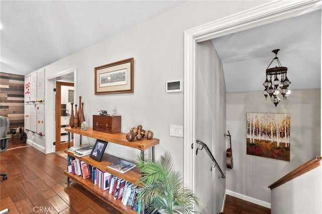 hallway with a notable chandelier and dark wood-type flooring