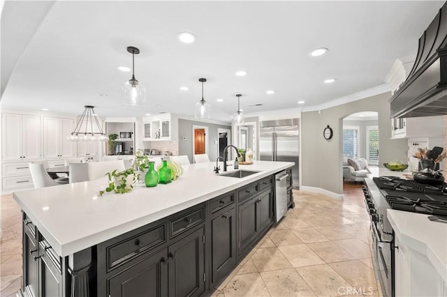 kitchen with sink, pendant lighting, a large island, and high quality appliances