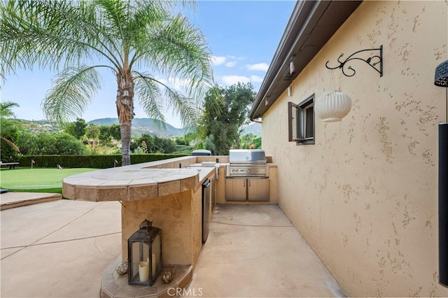 view of patio / terrace with area for grilling, a mountain view, and grilling area