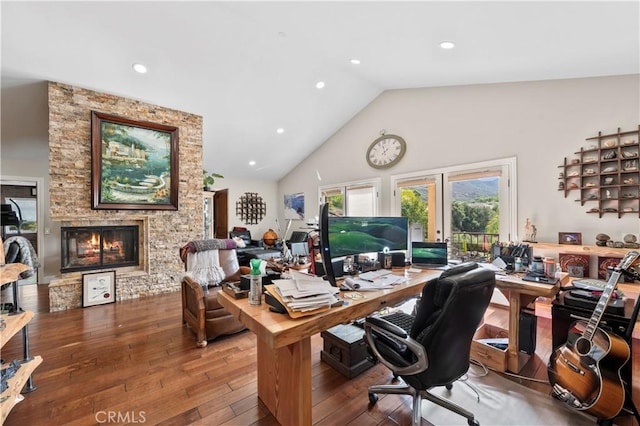 office featuring hardwood / wood-style floors, high vaulted ceiling, and a fireplace